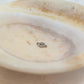 Paw Print Connector Charm showcased on a decorative plate, perfect for pet lovers' jewelry.