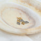 Paw Print Connector Charm in gold and silver on a decorative plate, perfect for pet lovers' jewelry.