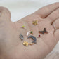 Mystery Charm Box featuring a variety of gold and silver charms displayed on a hand.