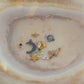 A variety of charms displayed in a bowl, featured in the Mystery Charm Box, showcasing unique designs and styles.