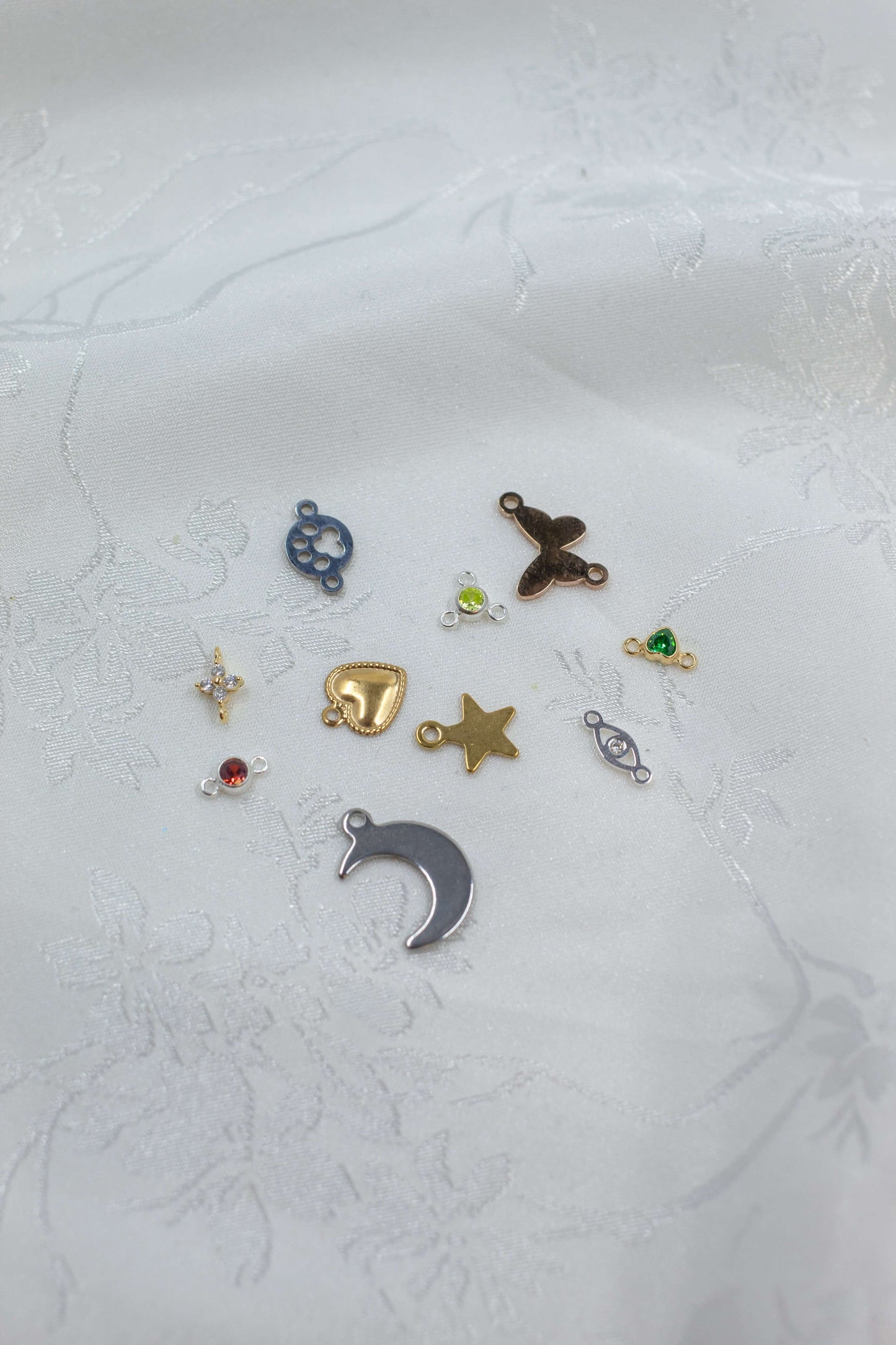 A collection of various charms featuring the Mystery Charm Box, including gold and silver designs.