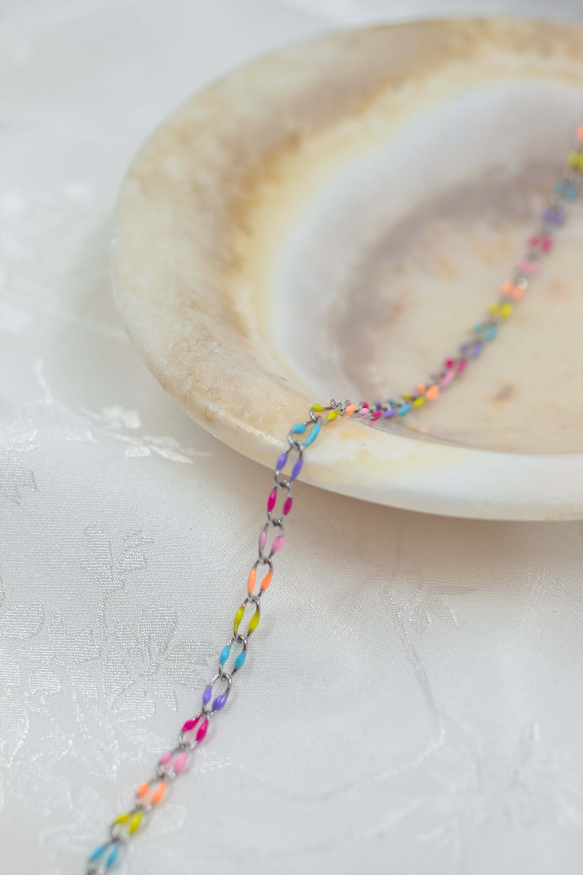 Colorful Marissa sterling silver enamel chain on a decorative plate.