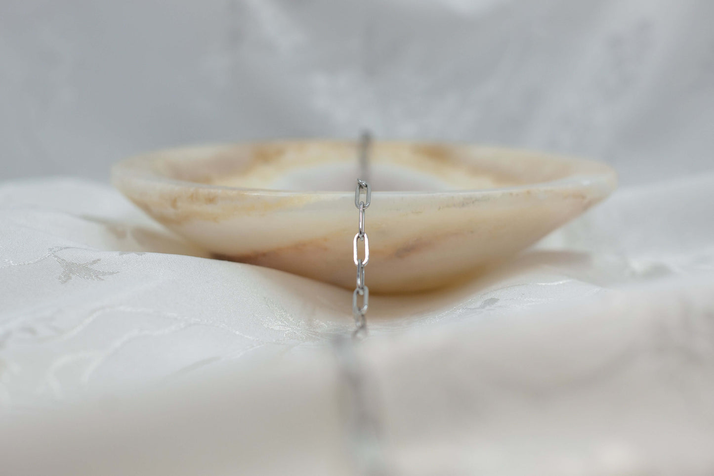 Austin chain displayed elegantly over a decorative bowl, showcasing the playful paperclip design.